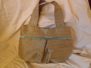 Penelope! A beautiful linen and silk blend. It's lined with a sky blue cotton and trimmed with a blue satin ribbon detail. Magnetic snap closure. Priced at $45