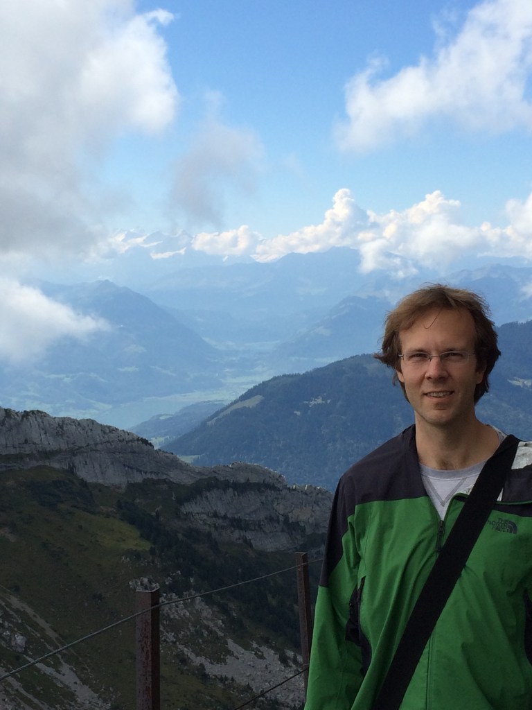 Mark on the front side of the mountain with snow-capped Alps in the background.
