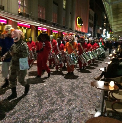 A drum and pipe corps marching through the streets.